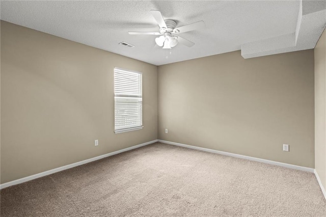 carpeted empty room featuring baseboards, visible vents, a textured ceiling, and ceiling fan