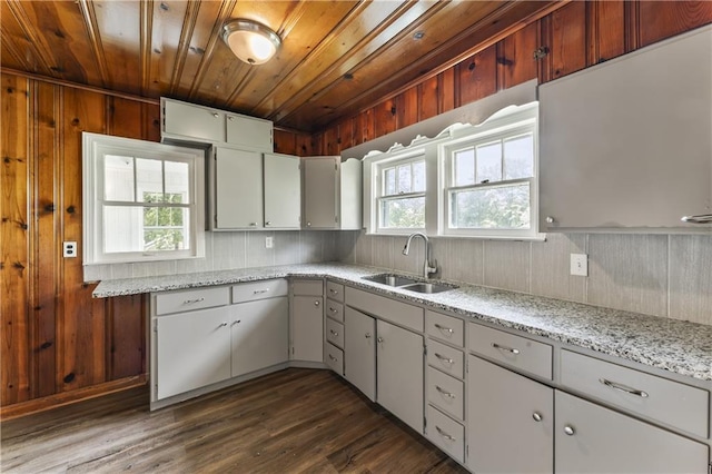 809 S Crysler Ave, Independence, MO 64052 - kitchen featuring a sink, wooden ceiling, wood walls, dark wood-style flooring, and light stone countertops