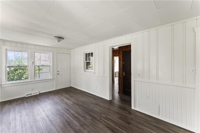 809 S Crysler Ave, Independence, MO 64052 - spare room with dark wood finished floors, a decorative wall, and baseboards
