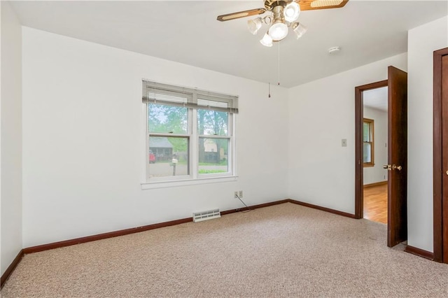 unfurnished room with baseboards, light carpet, a ceiling fan, and visible vents