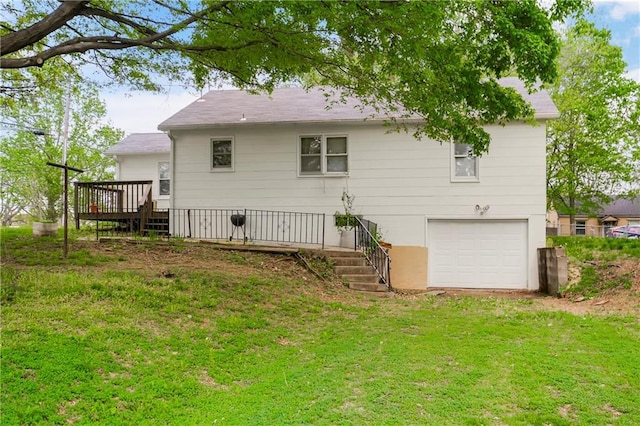 rear view of house with a yard, a deck, stairs, and a garage