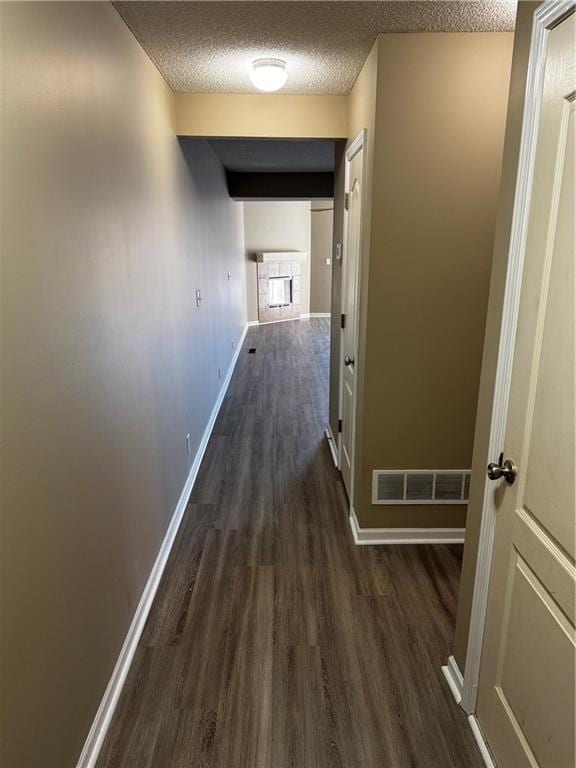 425 Hawthorne I Blvd, Warrensburg, MO 64093 - hallway featuring dark wood-style flooring, baseboards, a textured ceiling, and visible vents