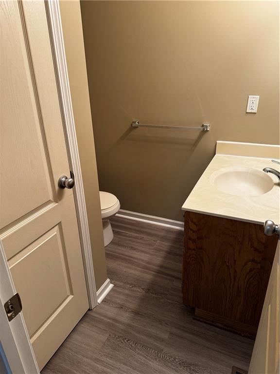 425 Hawthorne I Blvd, Warrensburg, MO 64093 - half bathroom with toilet, vanity, wood finished floors, and baseboards
