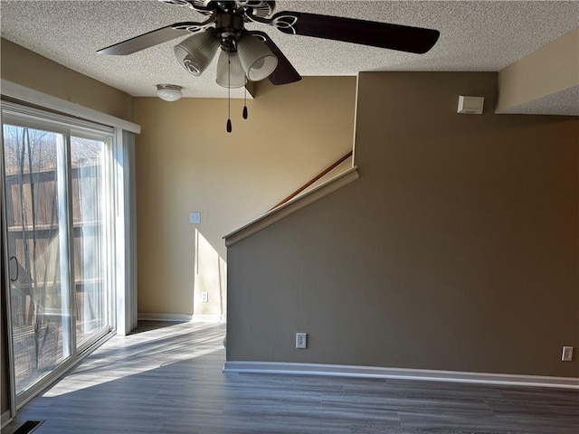 425 Hawthorne I Blvd, Warrensburg, MO 64093 - unfurnished living room with ceiling fan, a textured ceiling, wood finished floors, stairs, and baseboards