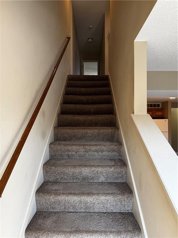 425 Hawthorne I Blvd, Warrensburg, MO 64093 - stairs featuring a textured ceiling