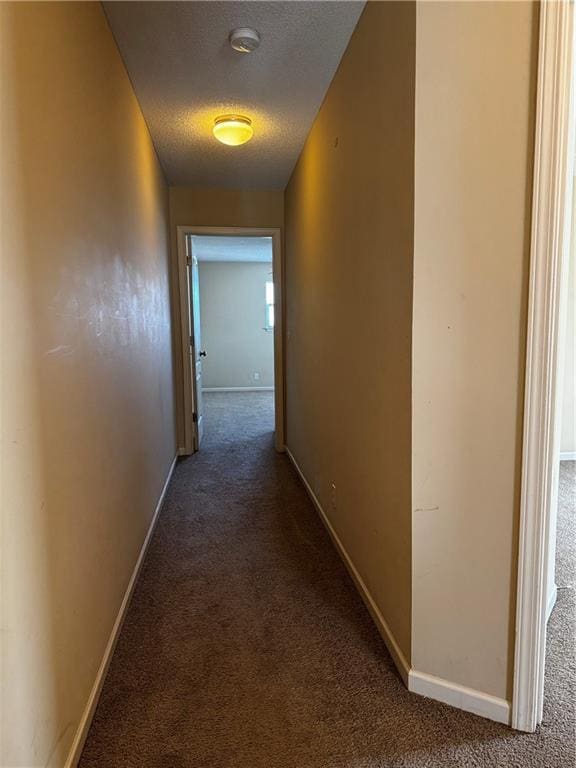 425 Hawthorne I Blvd, Warrensburg, MO 64093 - hall with a textured ceiling, dark colored carpet, and baseboards