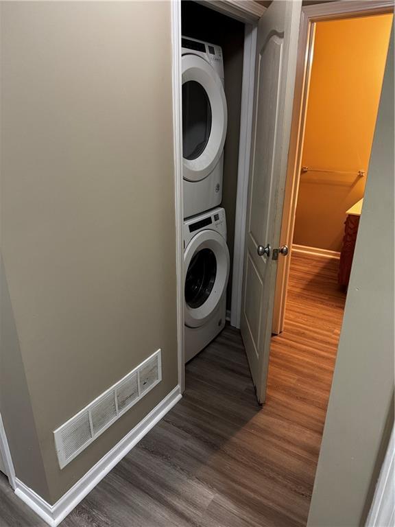 425 Hawthorne I Blvd, Warrensburg, MO 64093 - washroom with baseboards, stacked washing maching and dryer, and wood finished floors
