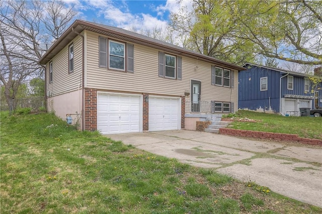 bi-level home with brick siding, an attached garage, a front yard, and driveway