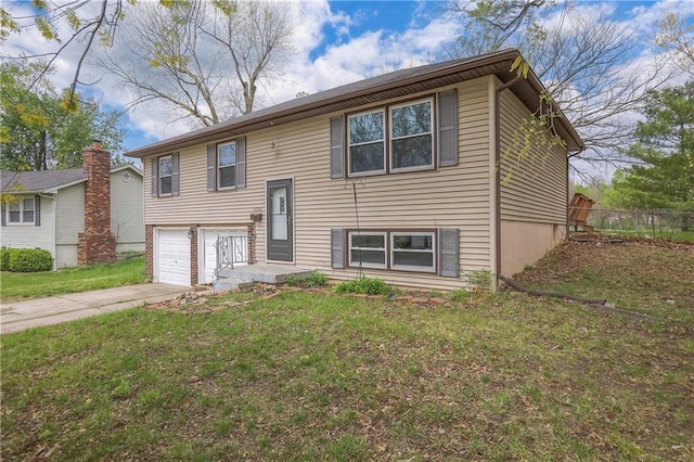 raised ranch with a garage, a front lawn, concrete driveway, and fence