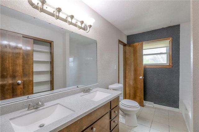 bathroom featuring tile patterned floors, a sink, double vanity, and toilet