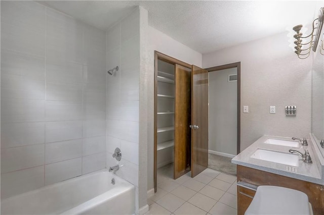 bathroom with washtub / shower combination, tile patterned flooring, visible vents, a sink, and a textured ceiling