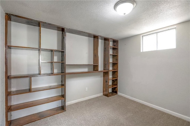 basement with carpet, baseboards, and a textured ceiling