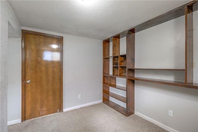 unfurnished bedroom featuring baseboards, carpet, and a textured ceiling