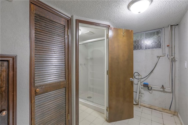 bathroom with tile patterned floors, baseboards, a textured ceiling, and a shower stall