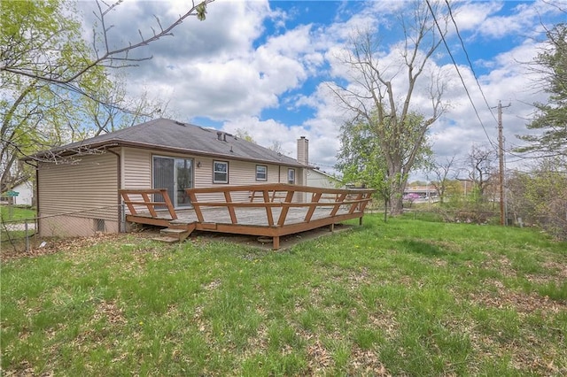 back of property with a lawn, a chimney, fence, and a deck
