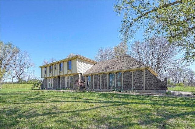 rear view of property with a yard and brick siding