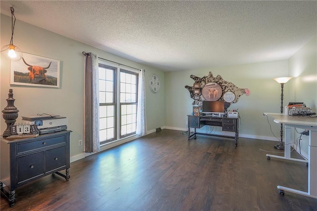 living area with a textured ceiling, baseboards, and wood finished floors