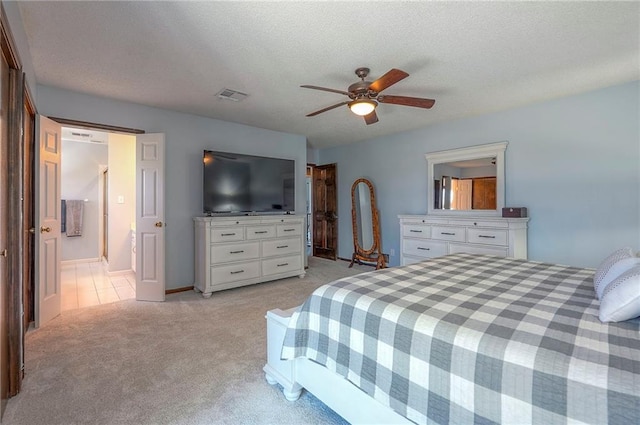 bedroom featuring visible vents, ceiling fan, light carpet, and a textured ceiling