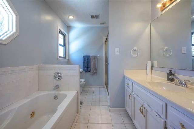full bath featuring a jetted tub, vanity, tile patterned floors, toilet, and visible vents