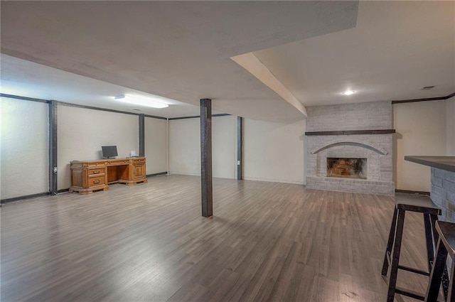 finished below grade area with a brick fireplace and wood finished floors