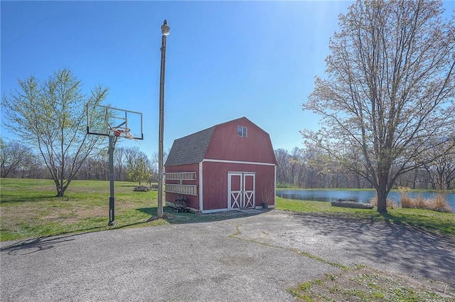 view of barn featuring a water view and a lawn