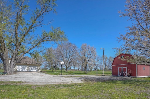 view of yard featuring a detached garage, an outdoor structure, and a barn
