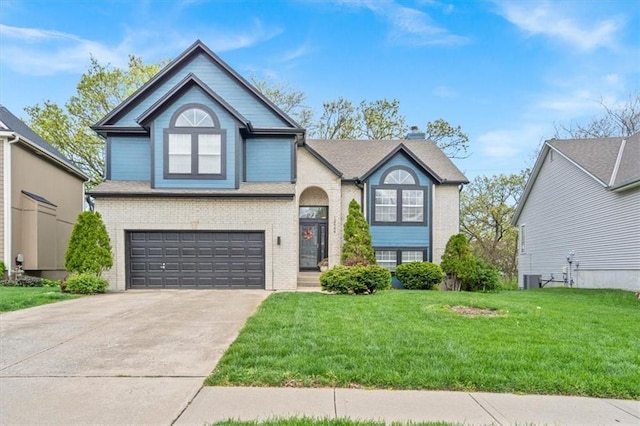 12848 S Rene St, Olathe, KS 66062 - view of front of house featuring an attached garage, a front lawn, driveway, and brick siding