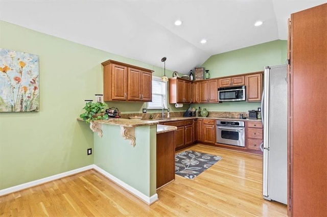 12848 S Rene St, Olathe, KS 66062 - kitchen featuring light wood finished floors, a peninsula, lofted ceiling, and stainless steel appliances