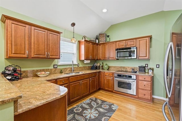 12848 S Rene St, Olathe, KS 66062 - kitchen featuring brown cabinets, appliances with stainless steel finishes, a sink, light wood finished floors, and lofted ceiling