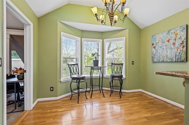 12848 S Rene St, Olathe, KS 66062 - dining space featuring a notable chandelier, wood finished floors, vaulted ceiling, and a wealth of natural light