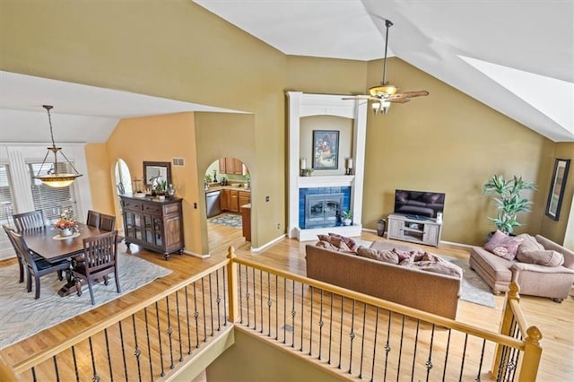 12848 S Rene St, Olathe, KS 66062 - living room featuring a glass covered fireplace, wood finished floors, lofted ceiling, baseboards, and a ceiling fan