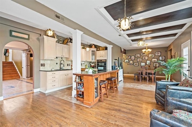 12848 S Rene St, Olathe, KS 66062 - interior space featuring a notable chandelier, a sink, light wood-style flooring, baseboards, and visible vents