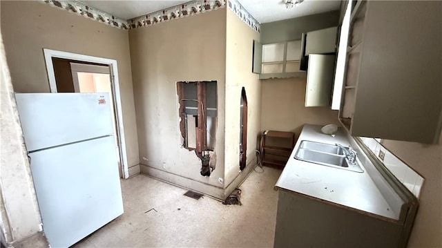2901 Farrow Ave, Kansas City, KS 66104 - kitchen featuring baseboards, light countertops, freestanding refrigerator, light floors, and a sink