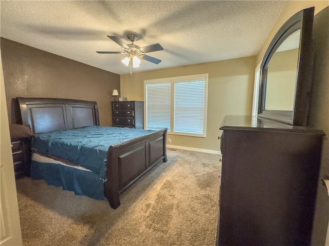 bedroom with ceiling fan, light colored carpet, baseboards, and a textured ceiling