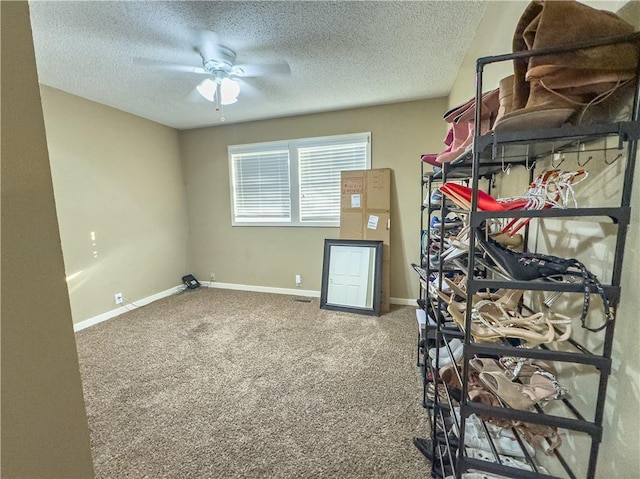 interior space with a textured ceiling, ceiling fan, and baseboards