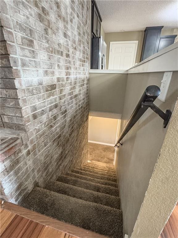 staircase featuring a textured ceiling