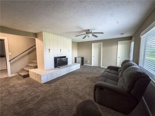 carpeted living room with stairs, baseboards, a textured ceiling, and ceiling fan