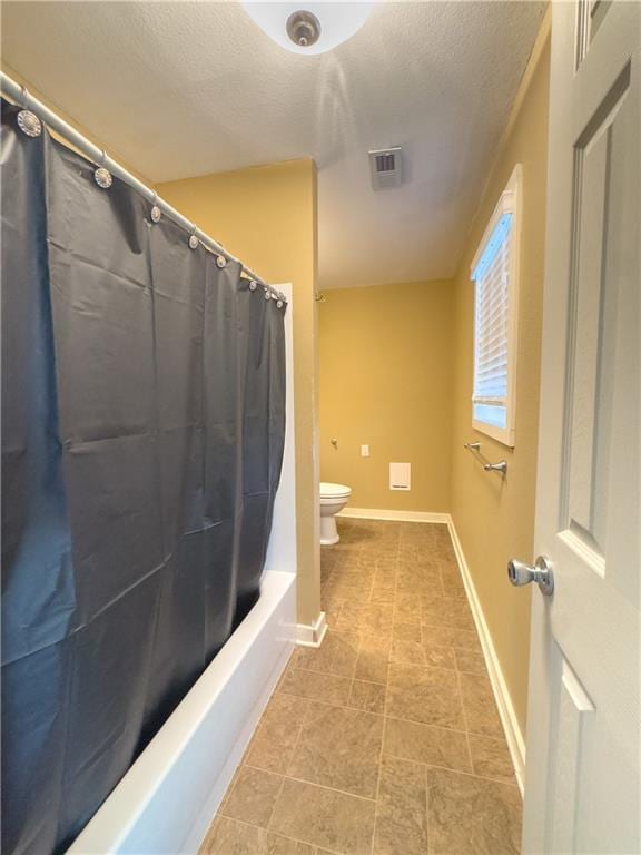 full bath with visible vents, toilet, baseboards, and a textured ceiling