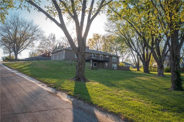 view of front of property with a front lawn, fence, an attached garage, and a chimney