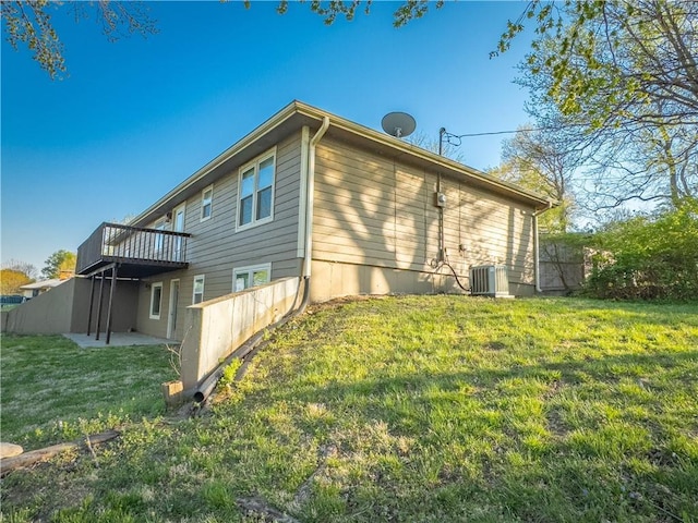 view of side of property featuring a patio, central AC, a wooden deck, and a lawn