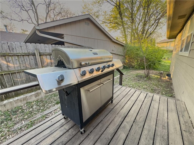wooden terrace with fence and a grill
