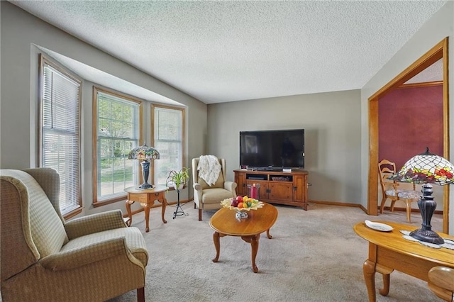 living room with baseboards, a textured ceiling, and light colored carpet