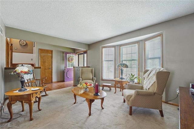 carpeted living area featuring baseboards, a textured ceiling, and visible vents