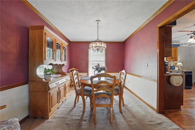 dining area with baseboards, ornamental molding, a textured ceiling, and a chandelier