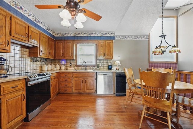 kitchen featuring light countertops, appliances with stainless steel finishes, a sink, and wood finished floors