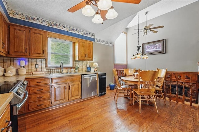 kitchen with brown cabinetry, a textured ceiling, and stainless steel appliances
