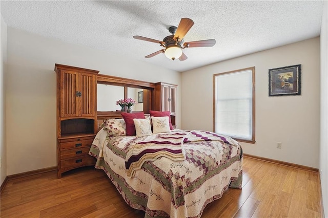 bedroom featuring a textured ceiling, baseboards, ceiling fan, and light wood-type flooring