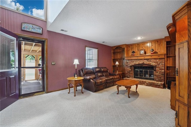 living area with plenty of natural light, a brick fireplace, visible vents, and light carpet