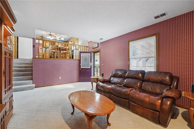 carpeted living room with a textured ceiling, visible vents, and a dry bar