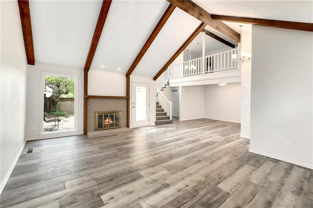 9738 Nieman Pl, Overland Park, KS 66214 - unfurnished living room featuring an inviting chandelier, a brick fireplace, beam ceiling, and stairway
